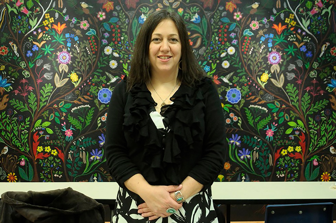 Christi Belcourt photographed in front of her large, elaborate artwork entitled “My Heart (Is Beautiful).”