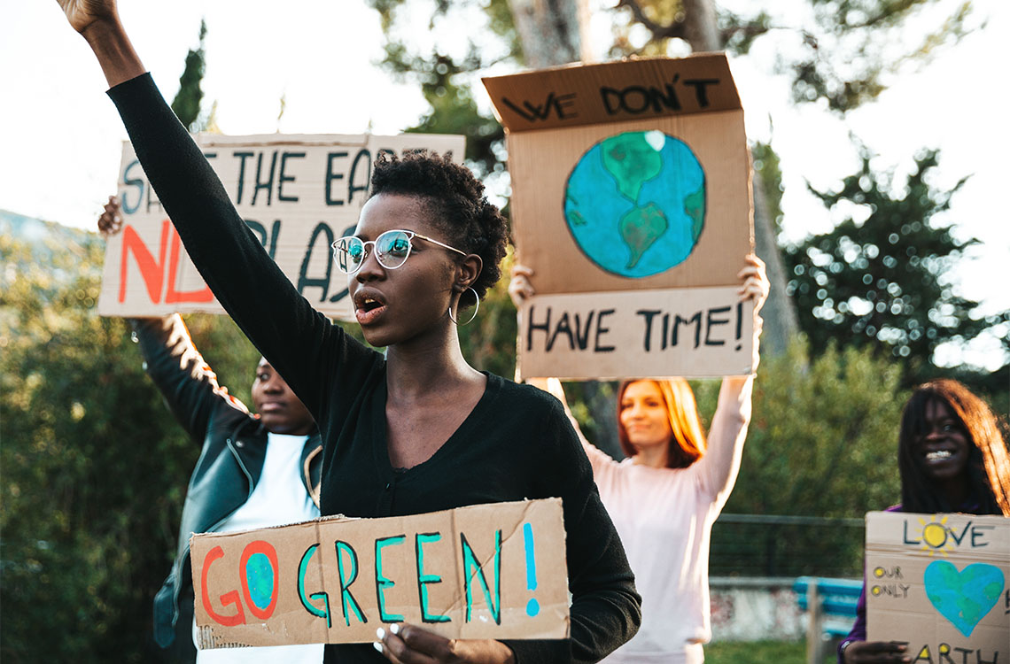 A group of protestors at an environmental rally holding up signs.