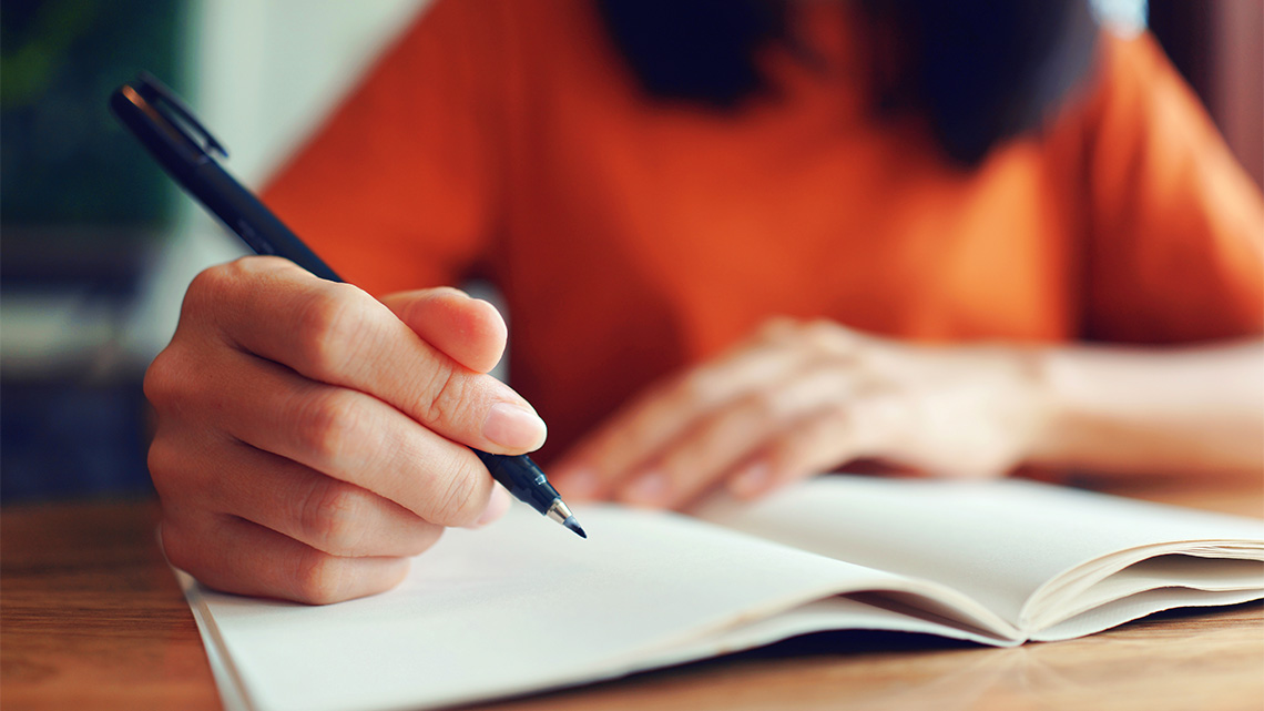 A person writing in a notebook.