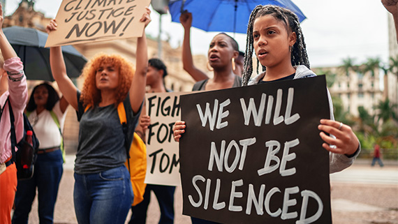 A group of protestors at a rally holding up signs.