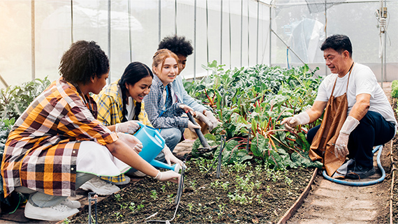Students working in a greenhouse garden.