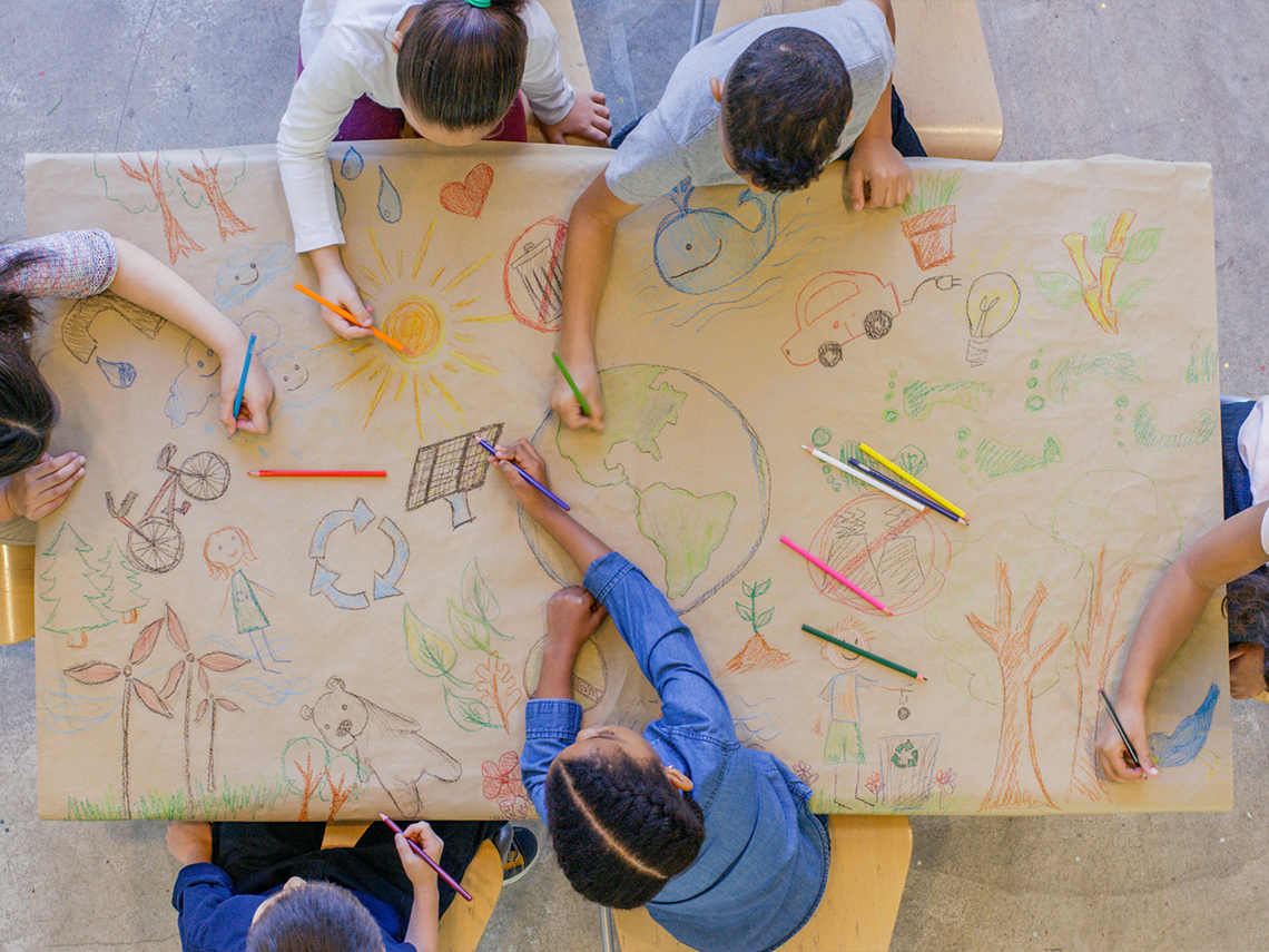 Students gather to make a poster about saving the environment and how to be kind to the planet.