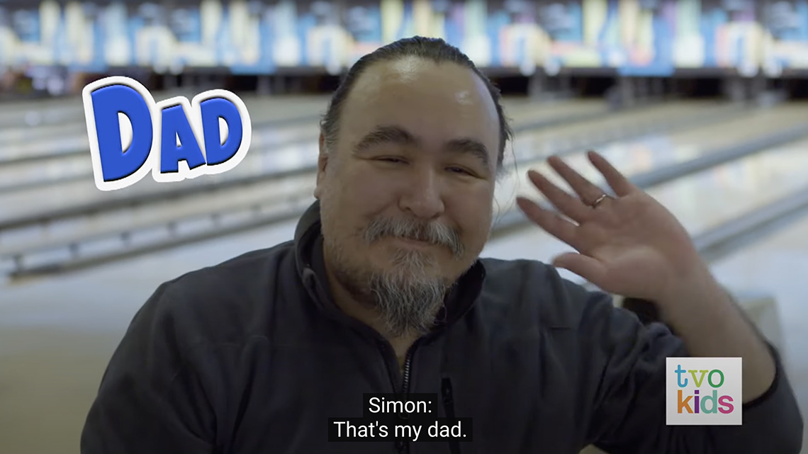 Simon's dad waves their hand just one time and does not say anything.