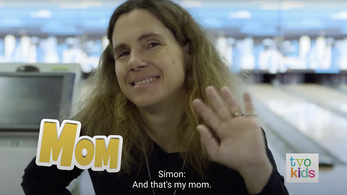 Simon's mom smiles and waves their hand a few times.