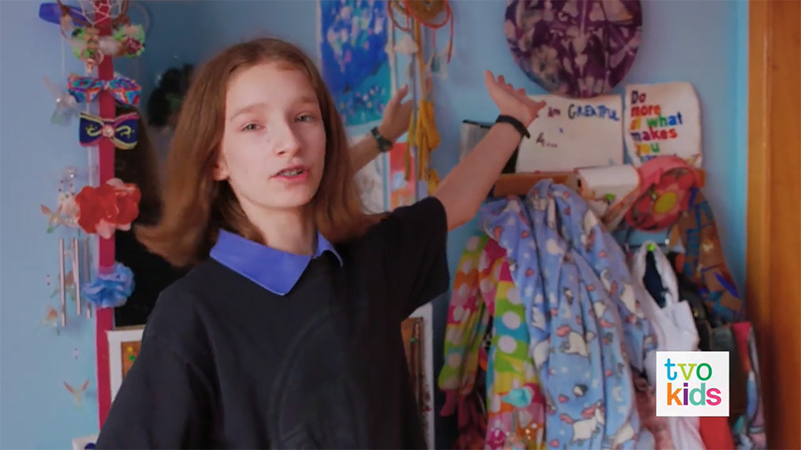 Emily gestures to her drum on the wall in her room.