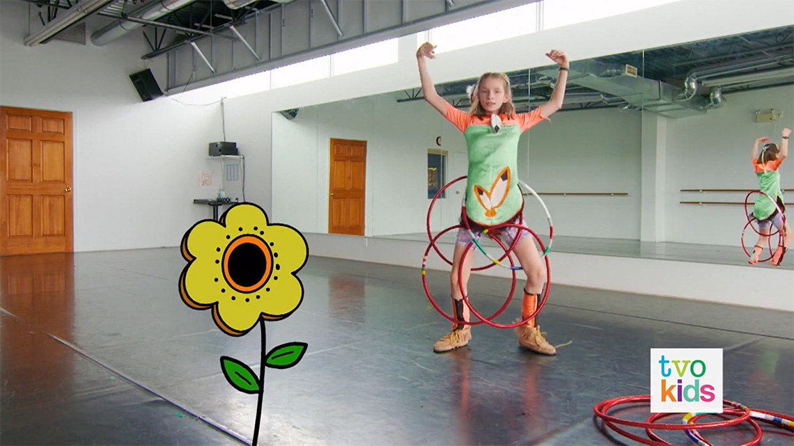 Emily shows how hoops on her legs and her back can help her make a flower shape.
