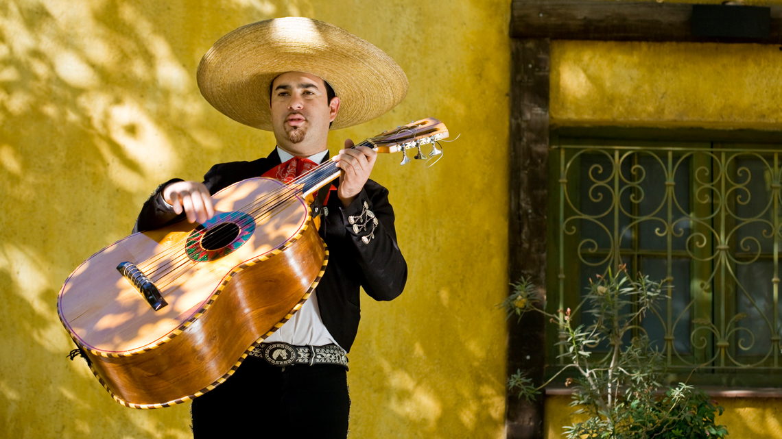 A Mariachi musician playing a guitarrón.