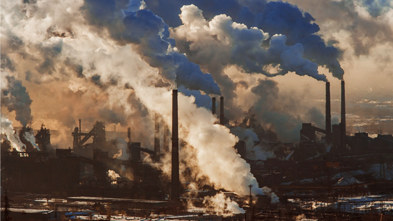An industrial area with many factories that have air pollution coming out of smokestacks.
