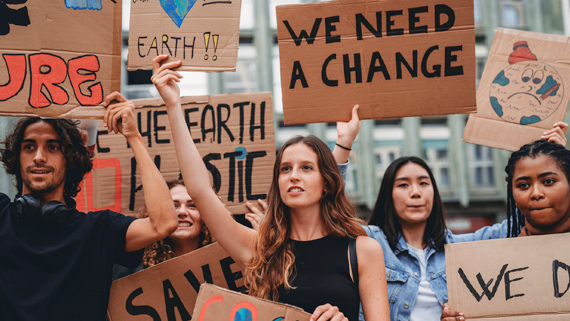 An organized group of people with signs bringing awareness about climate change.