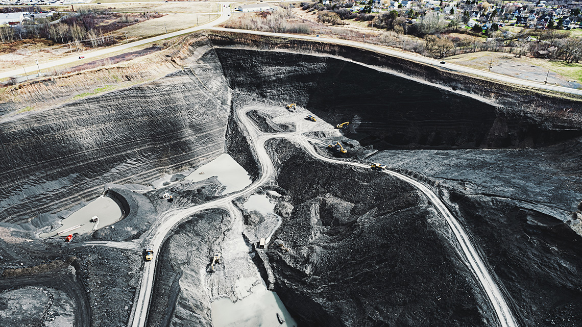 An open pit coal mine in Nova Scotia, with small roads leading deep down into the pit.