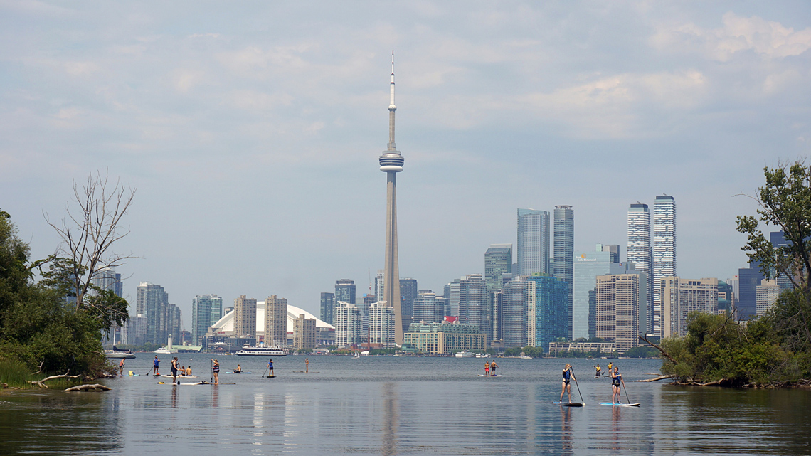 People paddleboarding on Lake Ontario with the Toronto skyline in the background