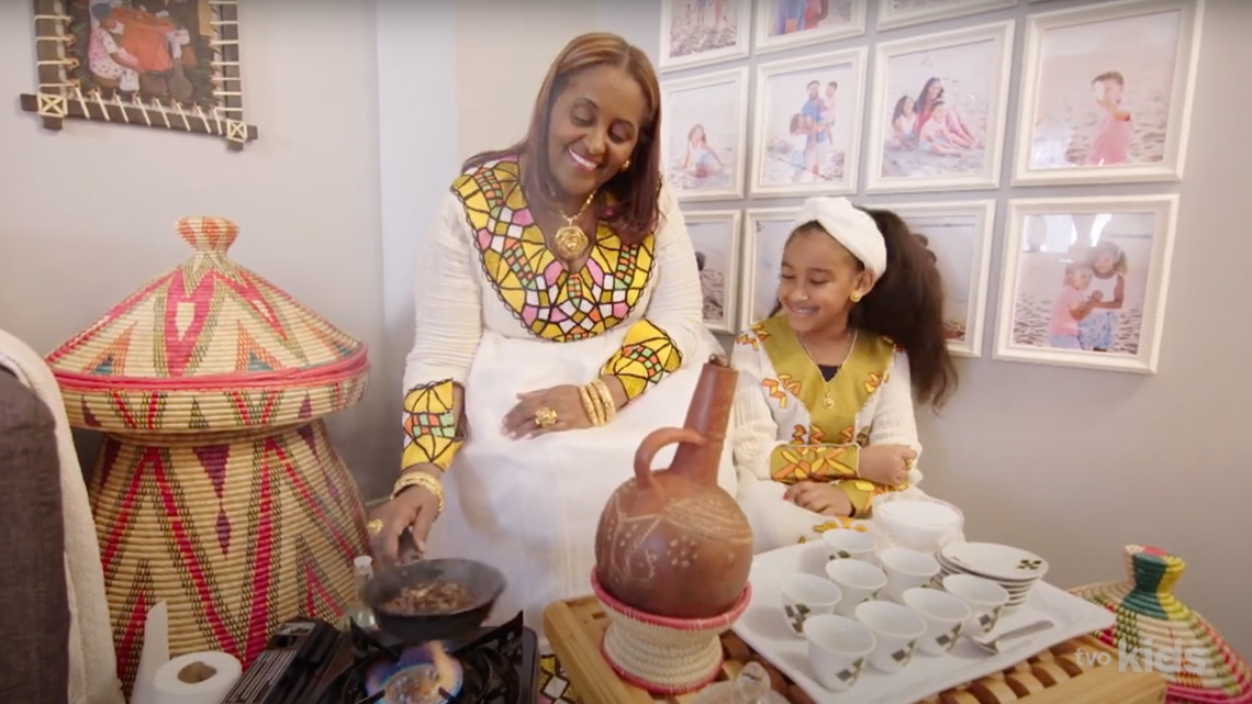 Leah and her grandmother are making coffee. They both are smiling.