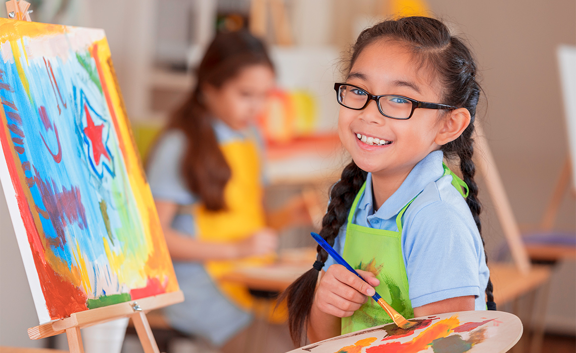 Smiling child painting.