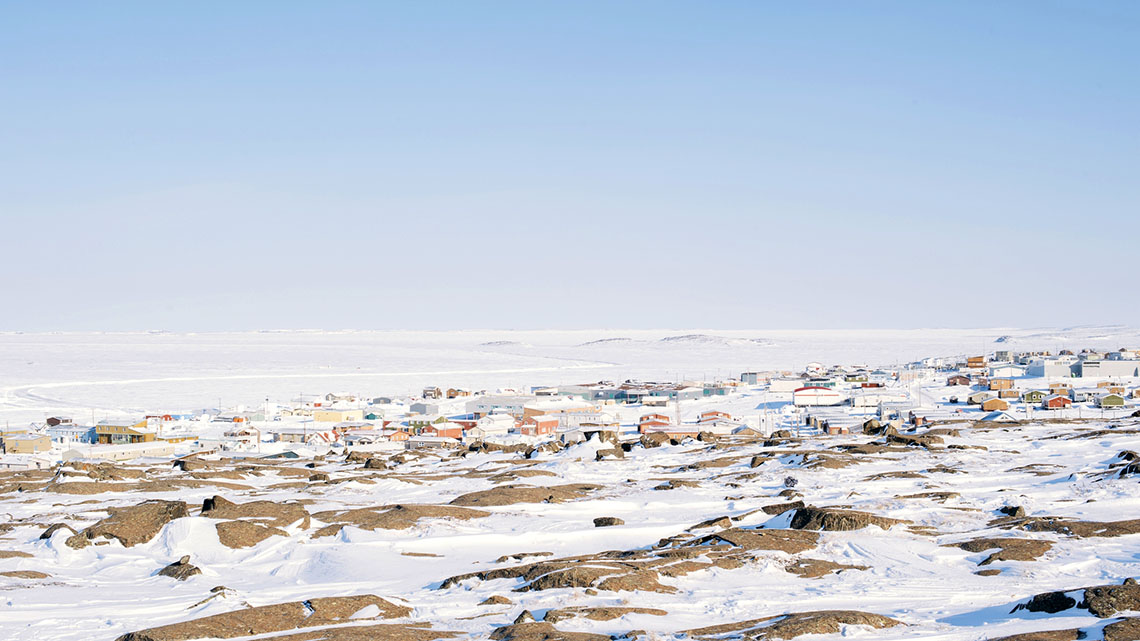 A small community of one-story buildings that are in a snowy landscape.