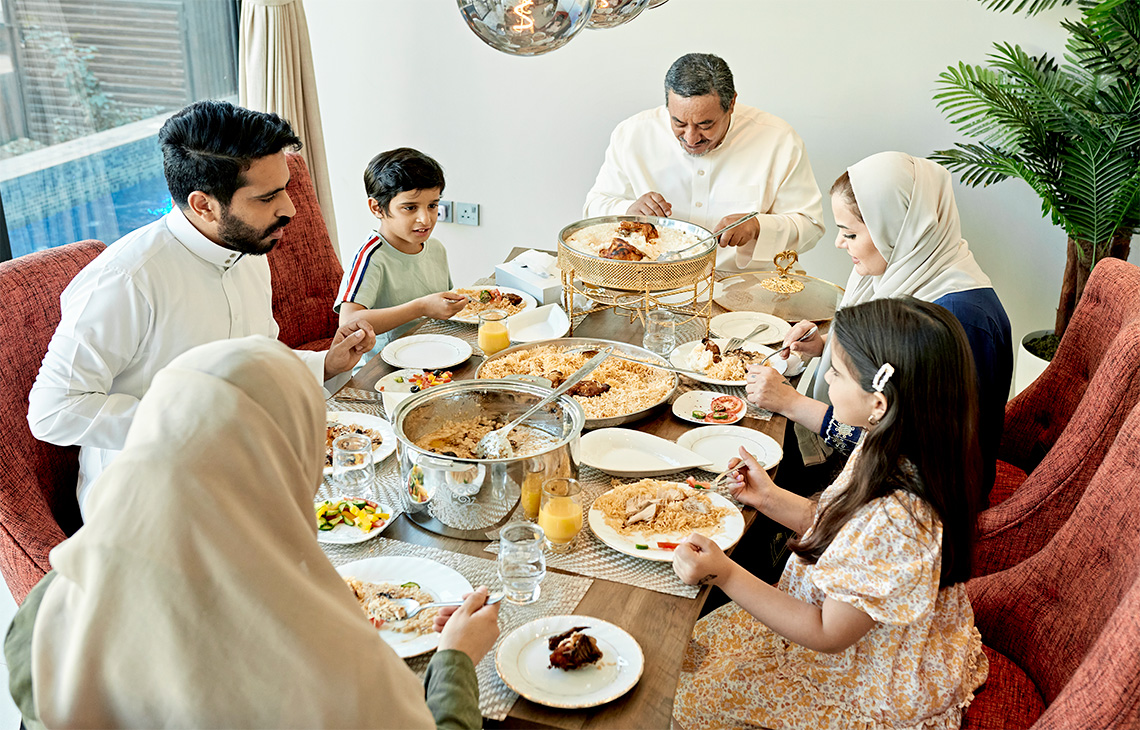 A Middle Eastern family enjoying a meal around a dining table.