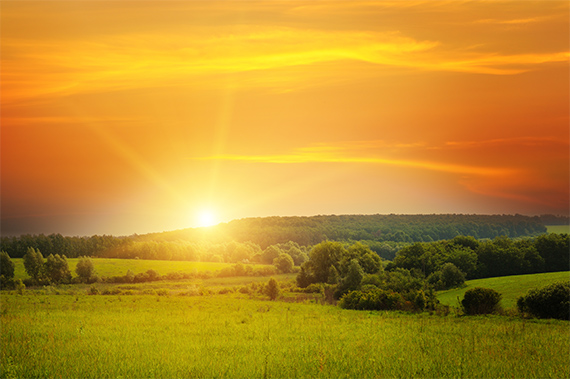 Illustration of dawn breaking. A sunrise over a horizon with the first rays of light piercing the dark sky.