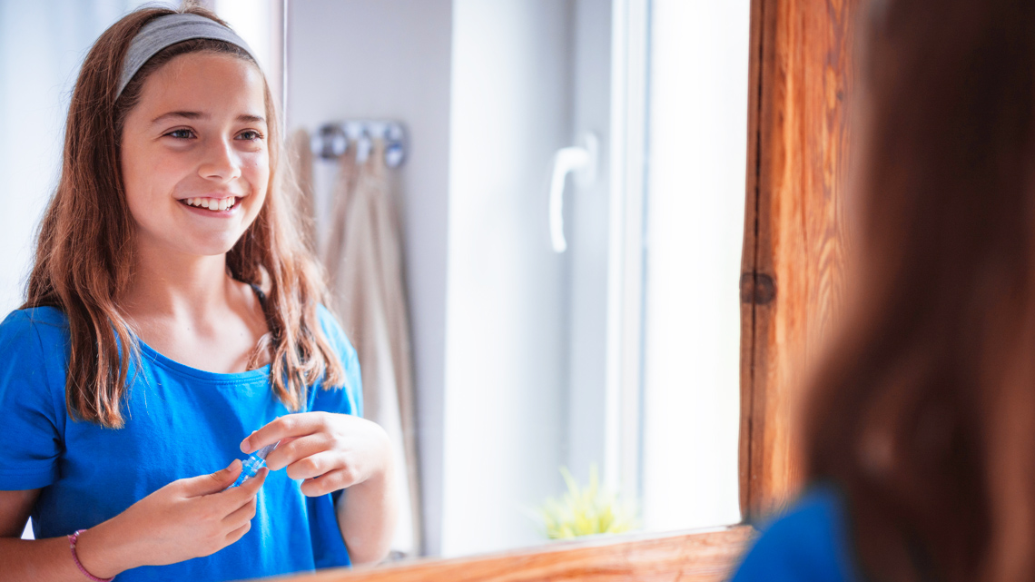 A child looking at themself in a mirror.