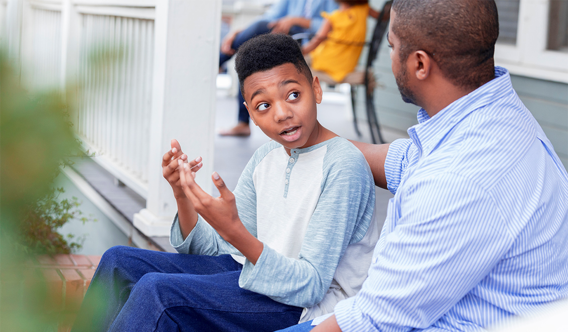 An adult and a child talking; the child looks surprised.