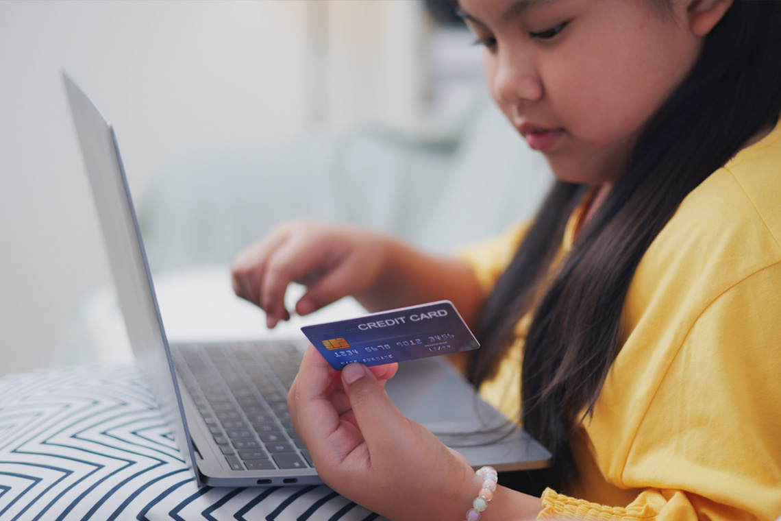 A learner reading information on a credit card while typing into a computer