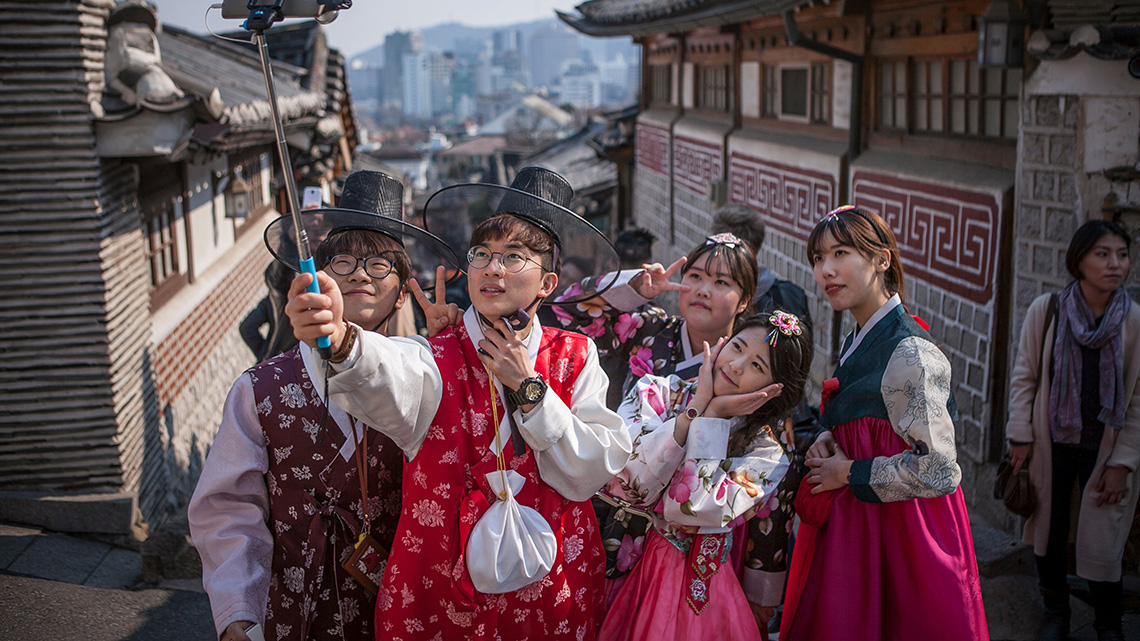 A group of people using a selfie stick to take a picture.