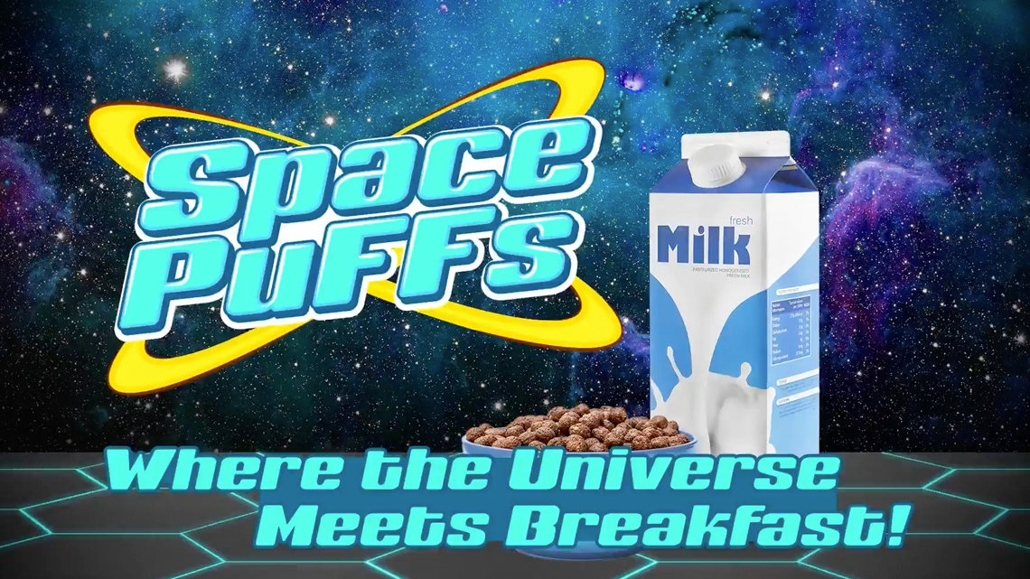 An image from the Space Puffs video with a bowl of cereal next to a carton of milk, and the phrase "Where the Universe Meets Breakfast!"