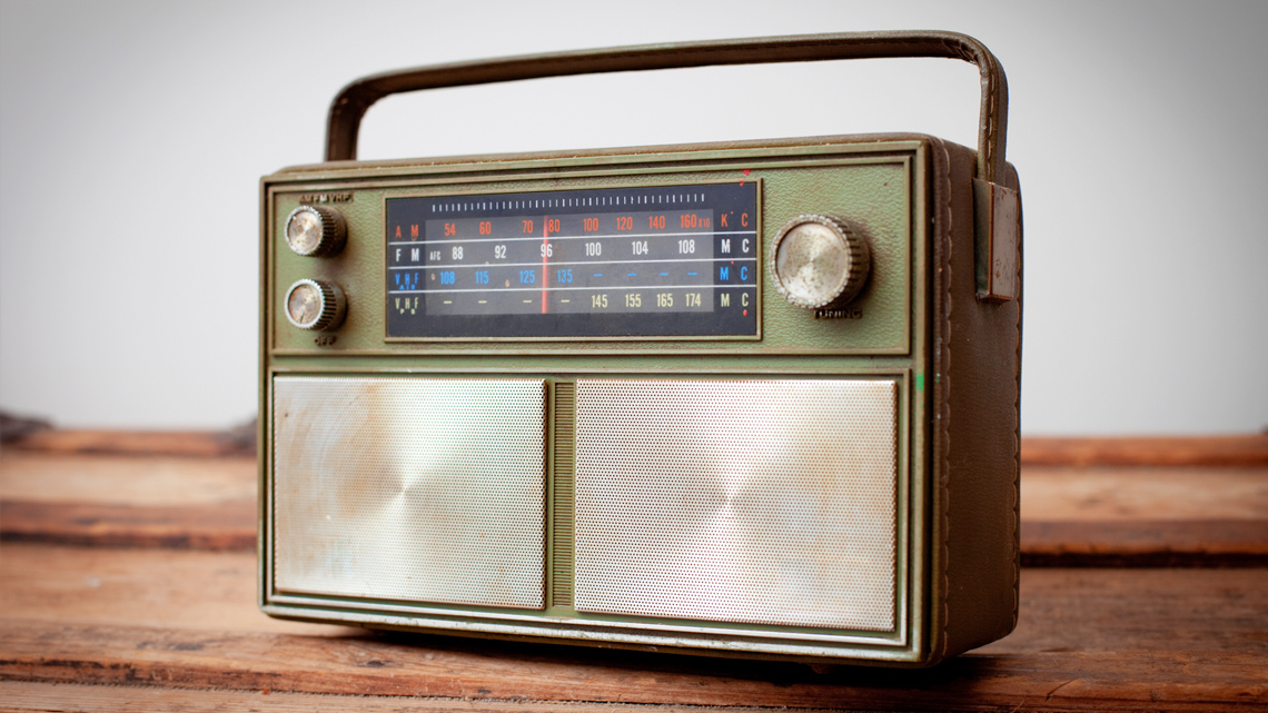A vintage portable AM/FM radio with manual tuning knobs