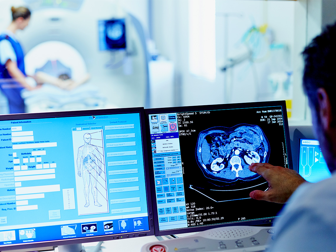 A doctor pointing at a medical image on a computer screen
