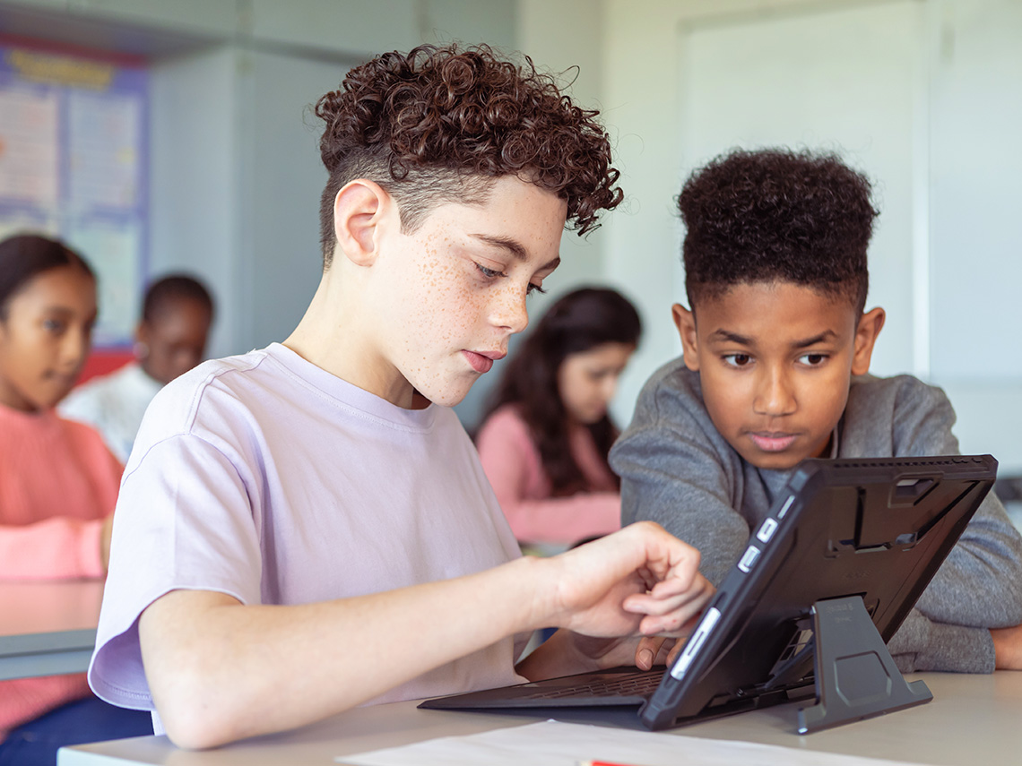 Students sharing a tablet in a classroom