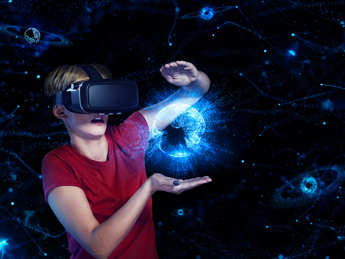 A person wearing virtual reality goggles with a digital representation of Earth appearing in front of them