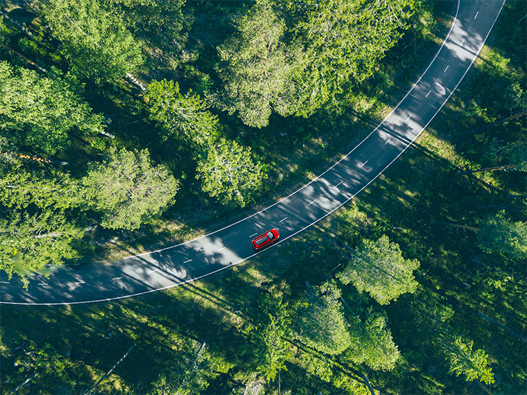 An aerial image of a driving car taken from the sky, which can be done with a drone or with a person in a helicopter.