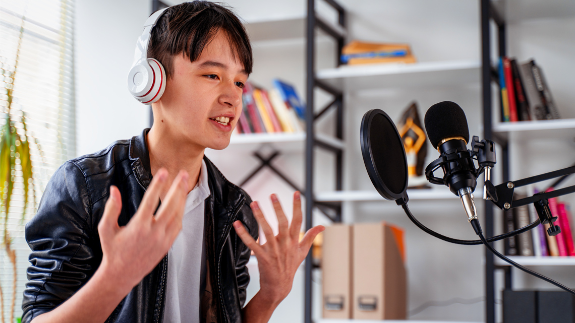 A boy recording into a microphone.