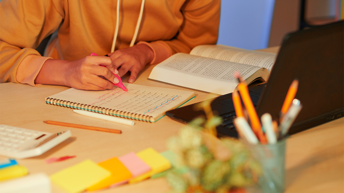 A learner highlighting text in their notebook.
