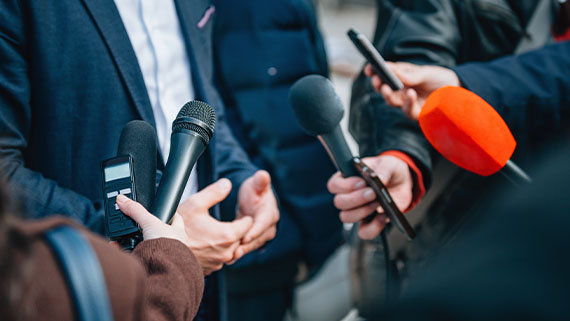 Multiple microphones held in the direction of a person speaking.