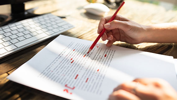 An editor making edits to text on paper.