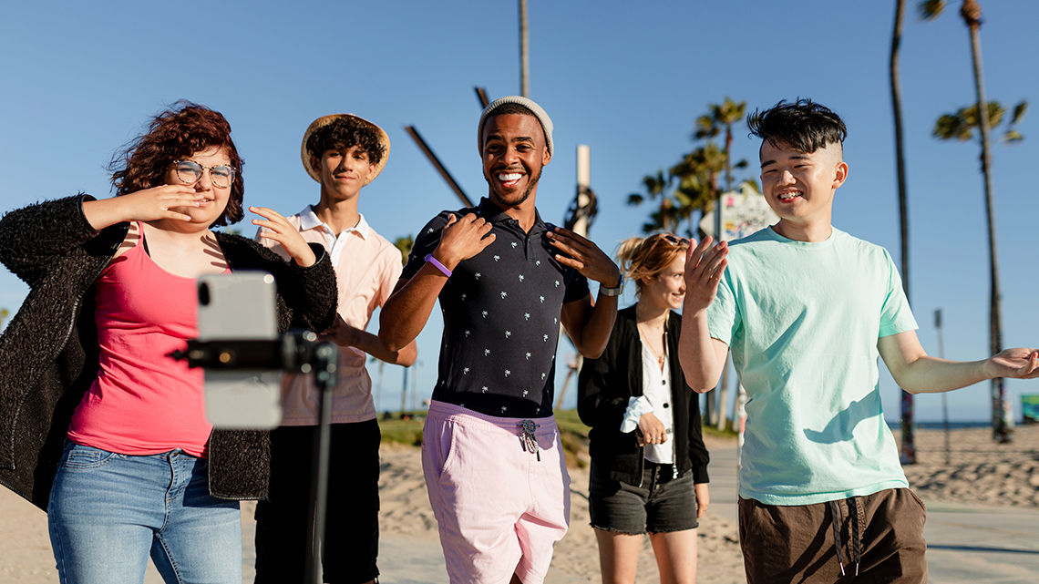 A group of teenagers taking a picture at the beach.