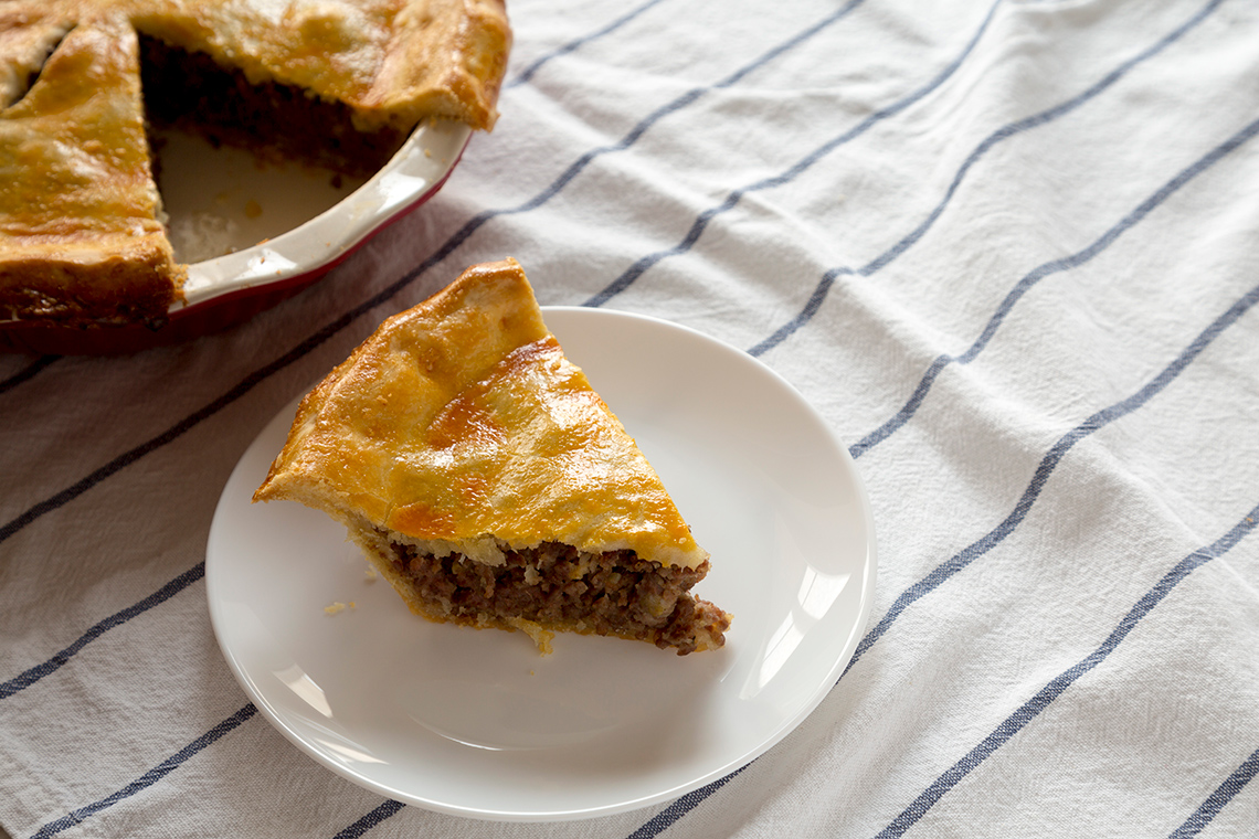 A slice of pie with meat filling.