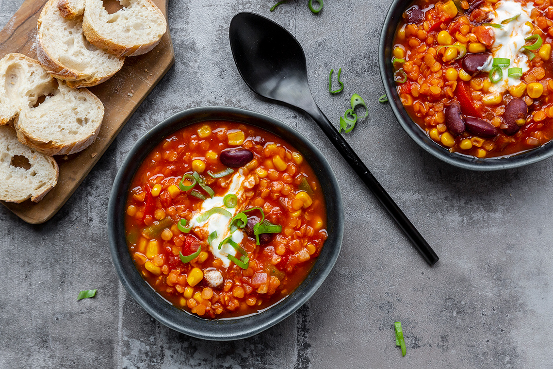 Two bowls of soup and bread.