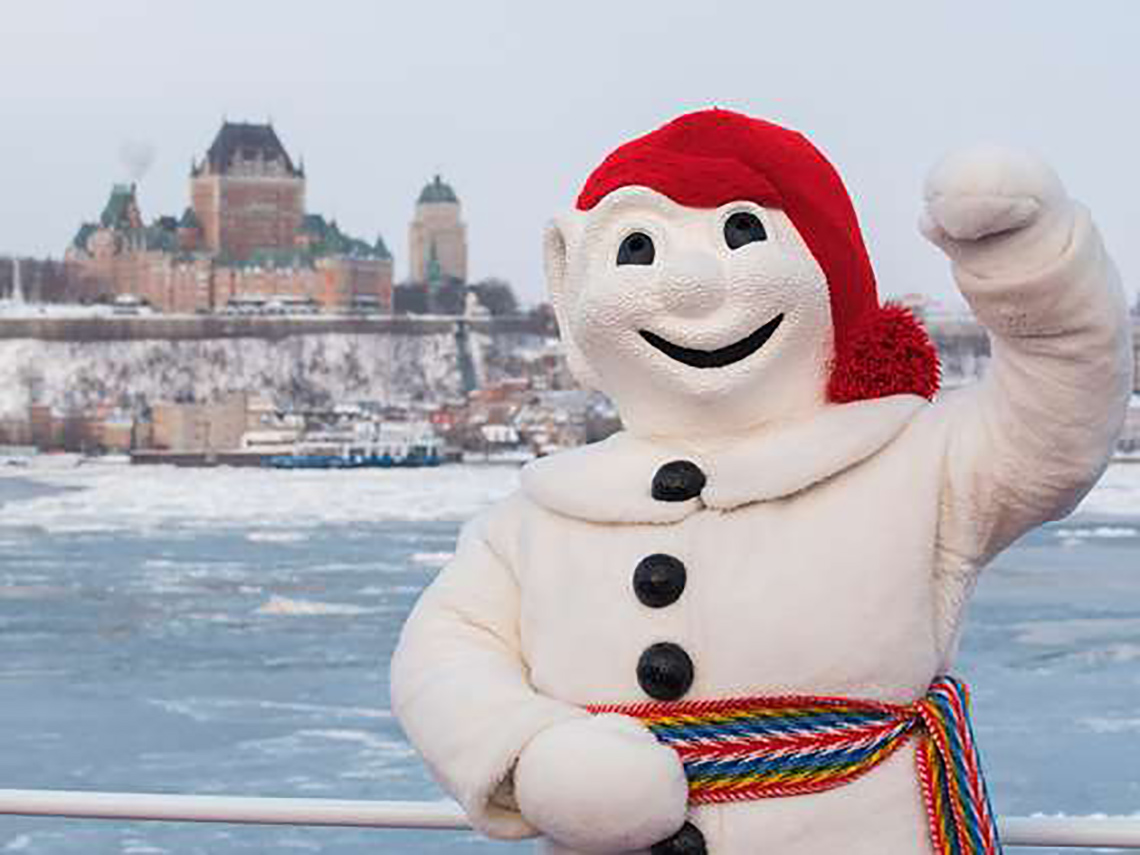 Bonhomme waving with le Château Frontenac in the background.