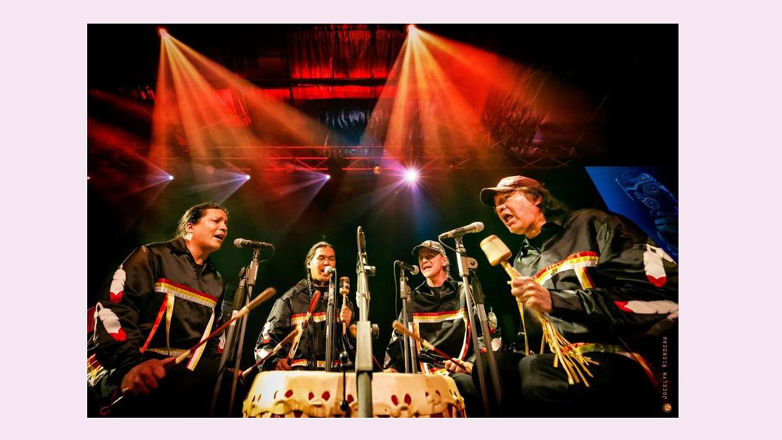 The group Buffalo Hat Singers performing a concert on stage.