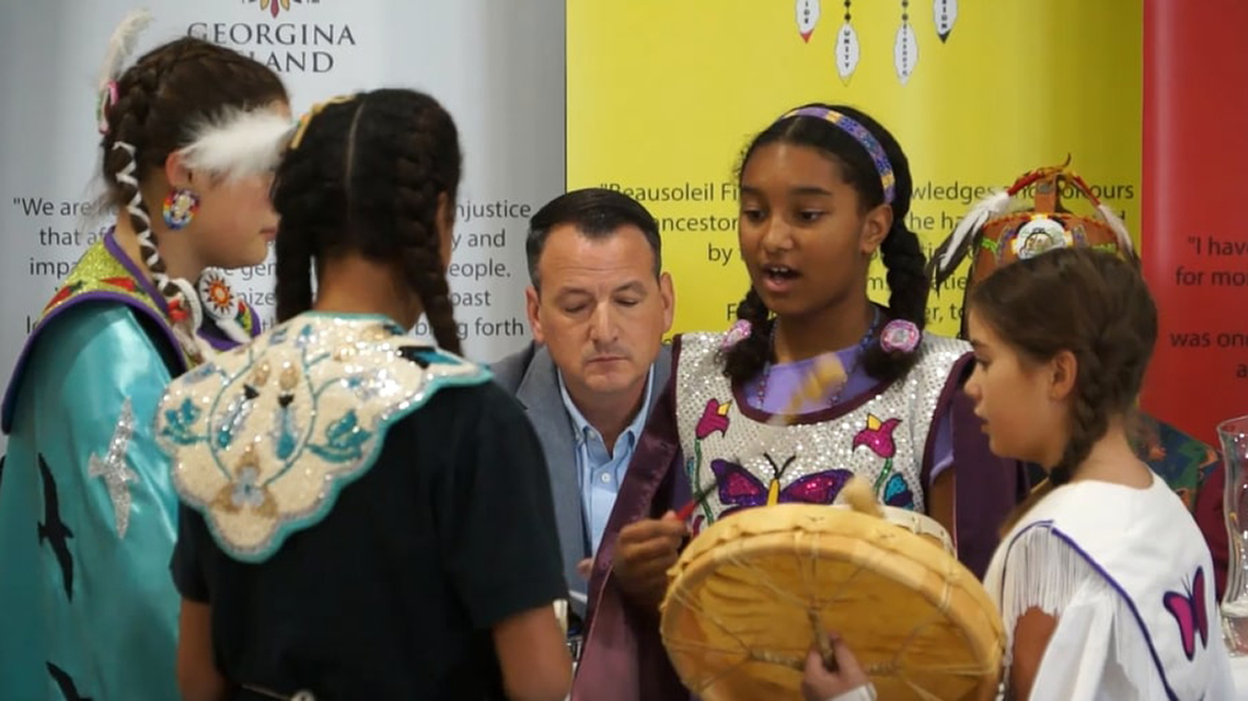 A group of student dancers gathered in a circle talking.