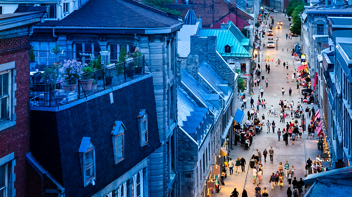 An aerial view of an old city street with people walking.