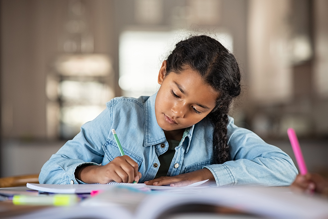 A girl writing in a notebook.