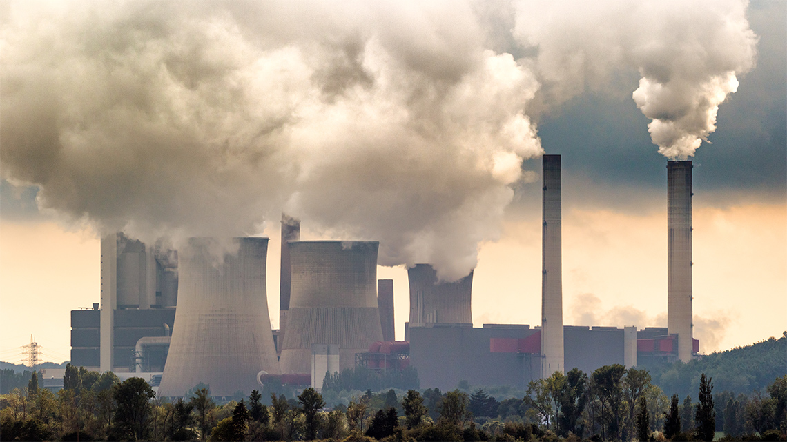 A series of smoke stacks that are emitting smoke.