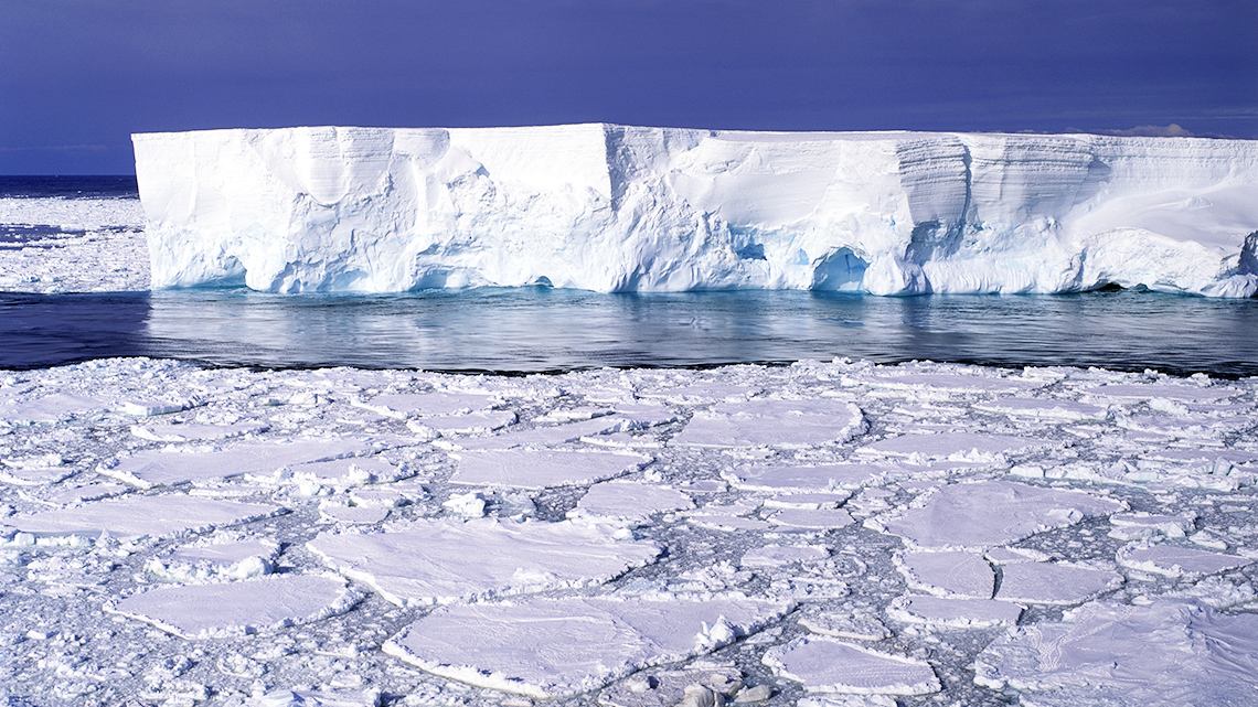 A landscape covered in ice and snow, with ice floating on water.