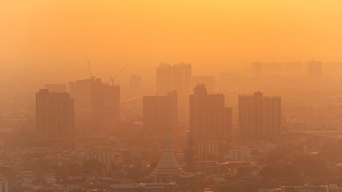 A city is covered in air pollution and is difficult to see even in the daytime.