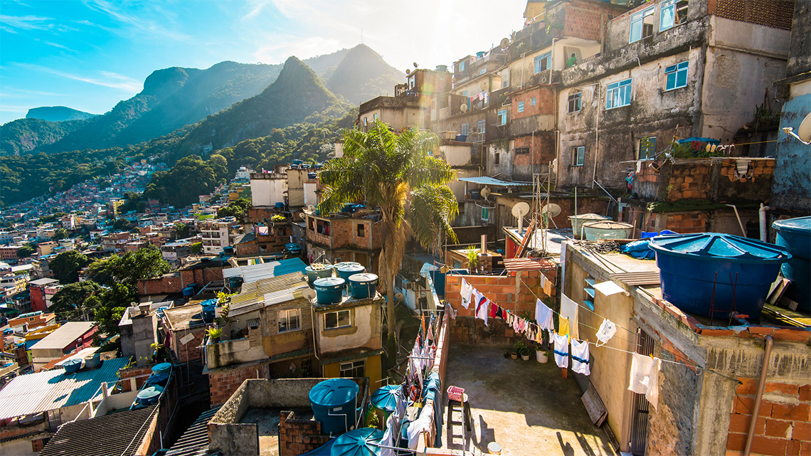 An image of two and three-story buildings built close together on a steep mountain
                                slope.