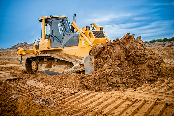 A bulldozer moving sand around in a construction site.