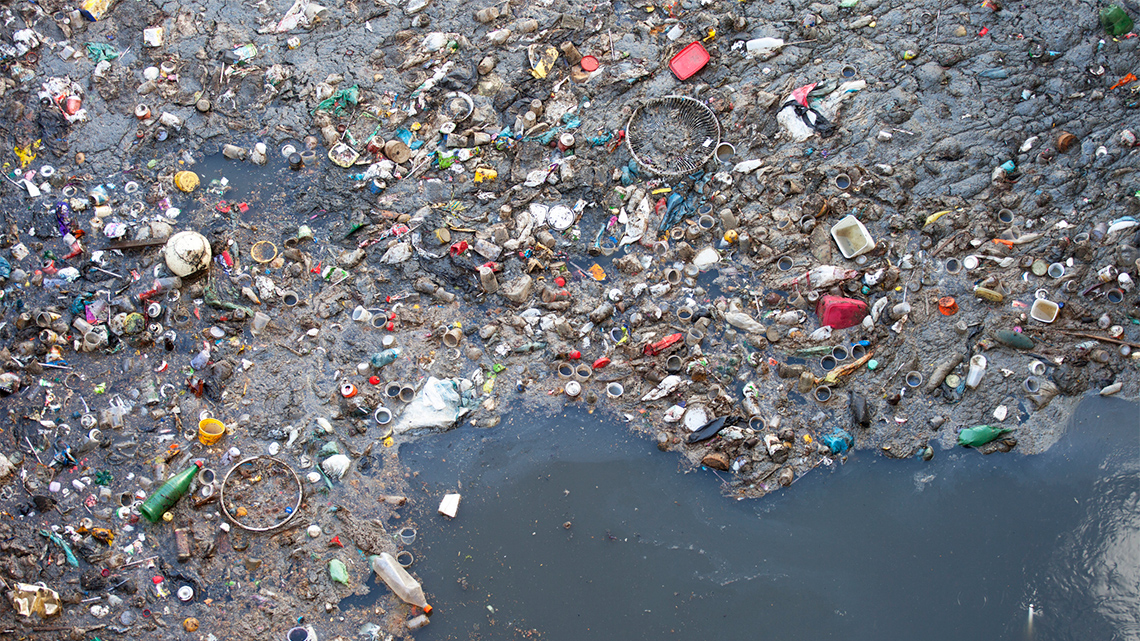 Lots of garbage such as cups, rings, bottles, and containers floating in water.