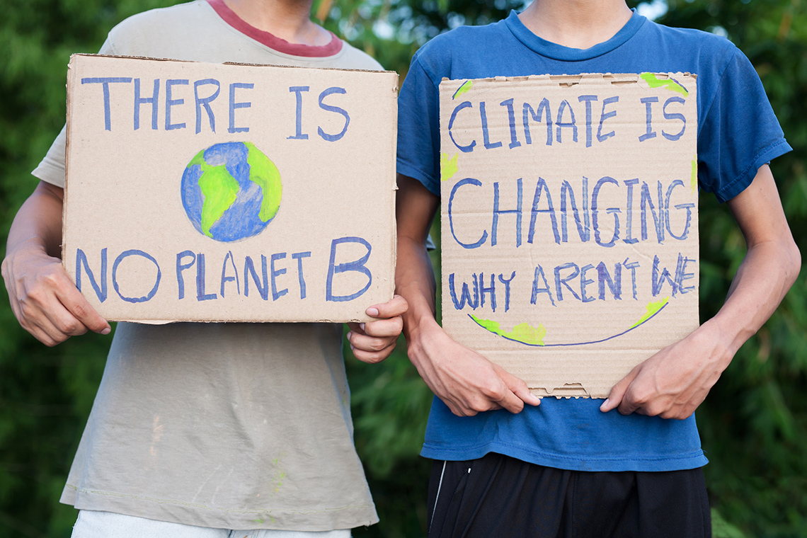 Raising Awareness About Climate Change An image of two kids with the signs “there is no planet b” and “climate is changing why aren’t we.”
