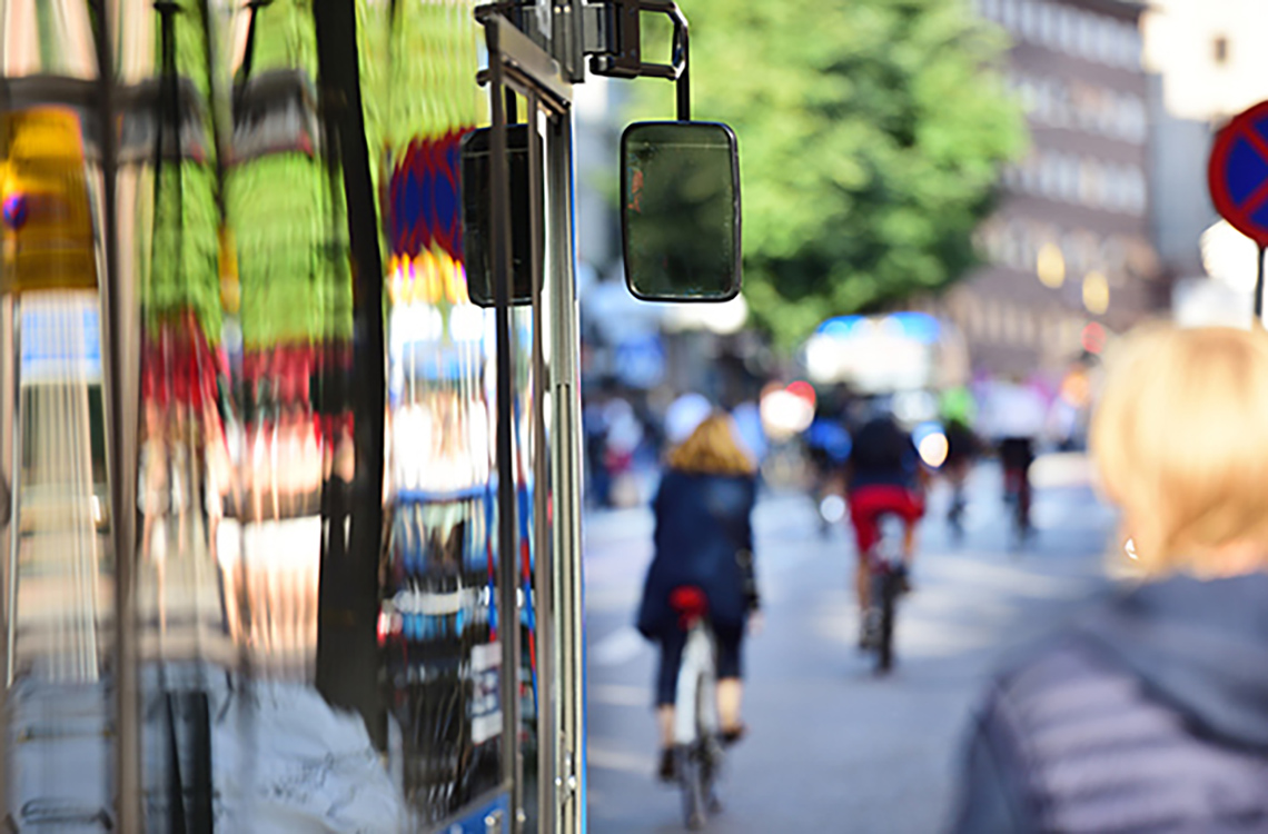 Cycling and Public Transportation A bus and a cyclist on an urban road.